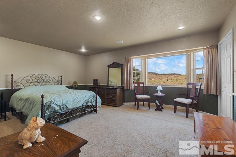 2920 Bullfrog Road Reno, NV 89521 - Photo 18 of 40 a spacious bedroom with a bed a table and large windows