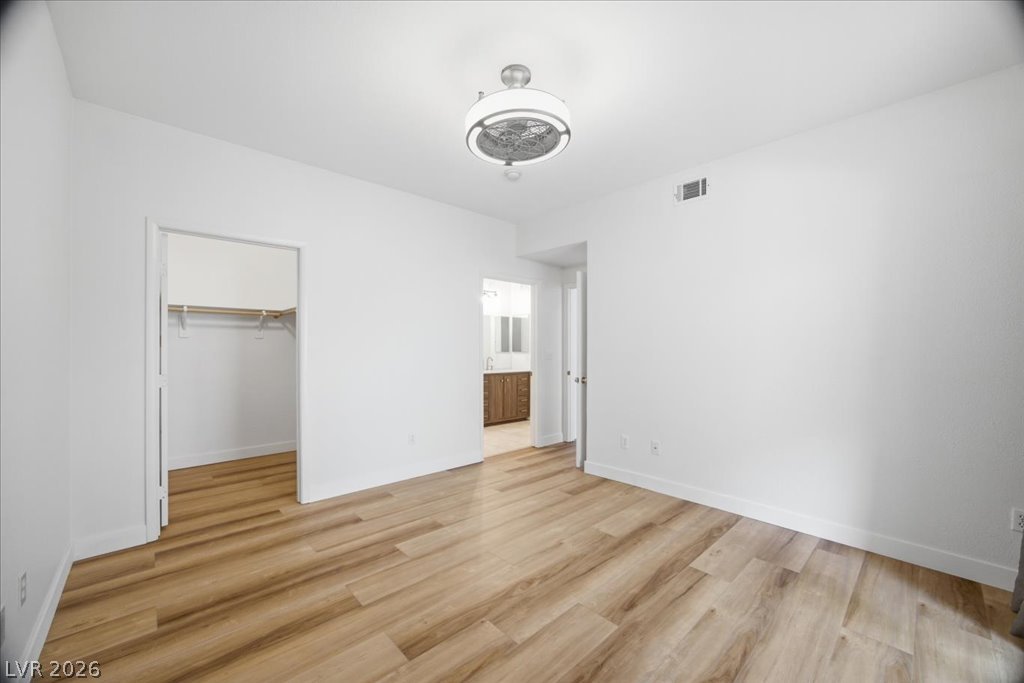 9050 West Warm Springs Road, Unit 1033 Las Vegas, NV 89148 - Photo 10 of 26 A pristine bedroom showcasing durable wood flooring and ample closet space, ready for personalization.