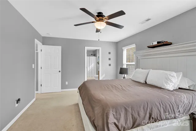 a bedroom with a large bed and ceiling fan
