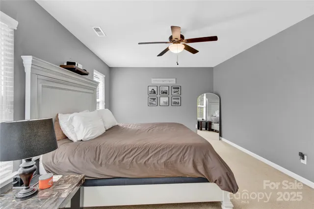 a bedroom with a bed and painting on the wall
