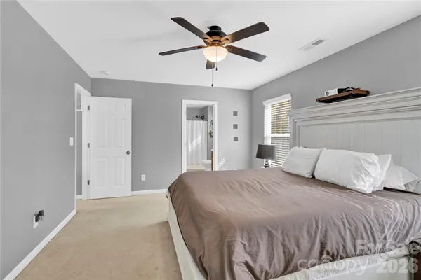 a bedroom with a large bed and ceiling fan