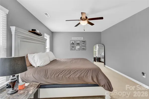 a bedroom with a bed and painting on the wall