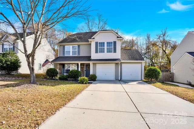a front view of a house with a yard and trees