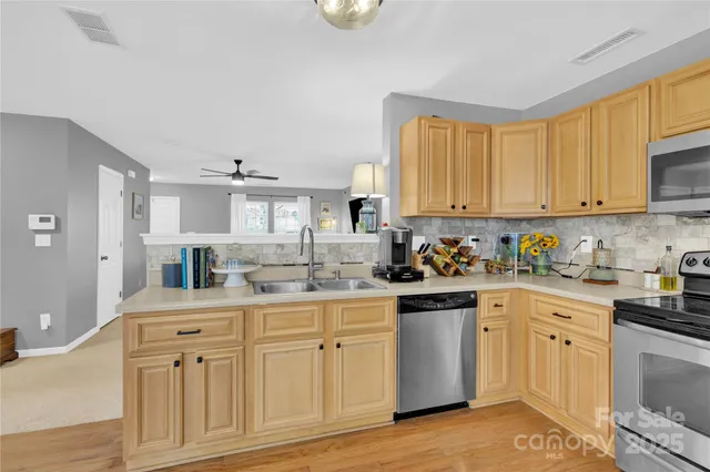 a kitchen with white cabinets and sink