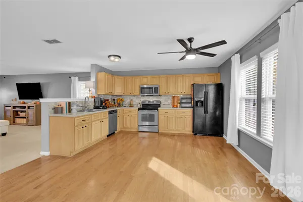 a kitchen with refrigerator cabinets and wooden floor