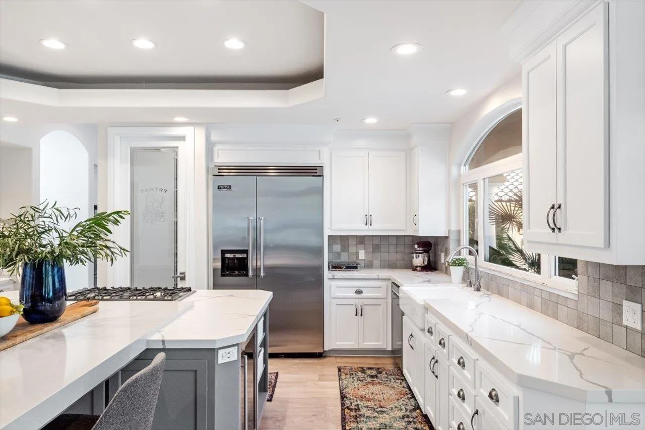 16270 Windpiper Road Poway, CA 92064 - Photo 10 of 65 a kitchen with stainless steel appliances kitchen island granite countertop a sink a stove and a refrigerator