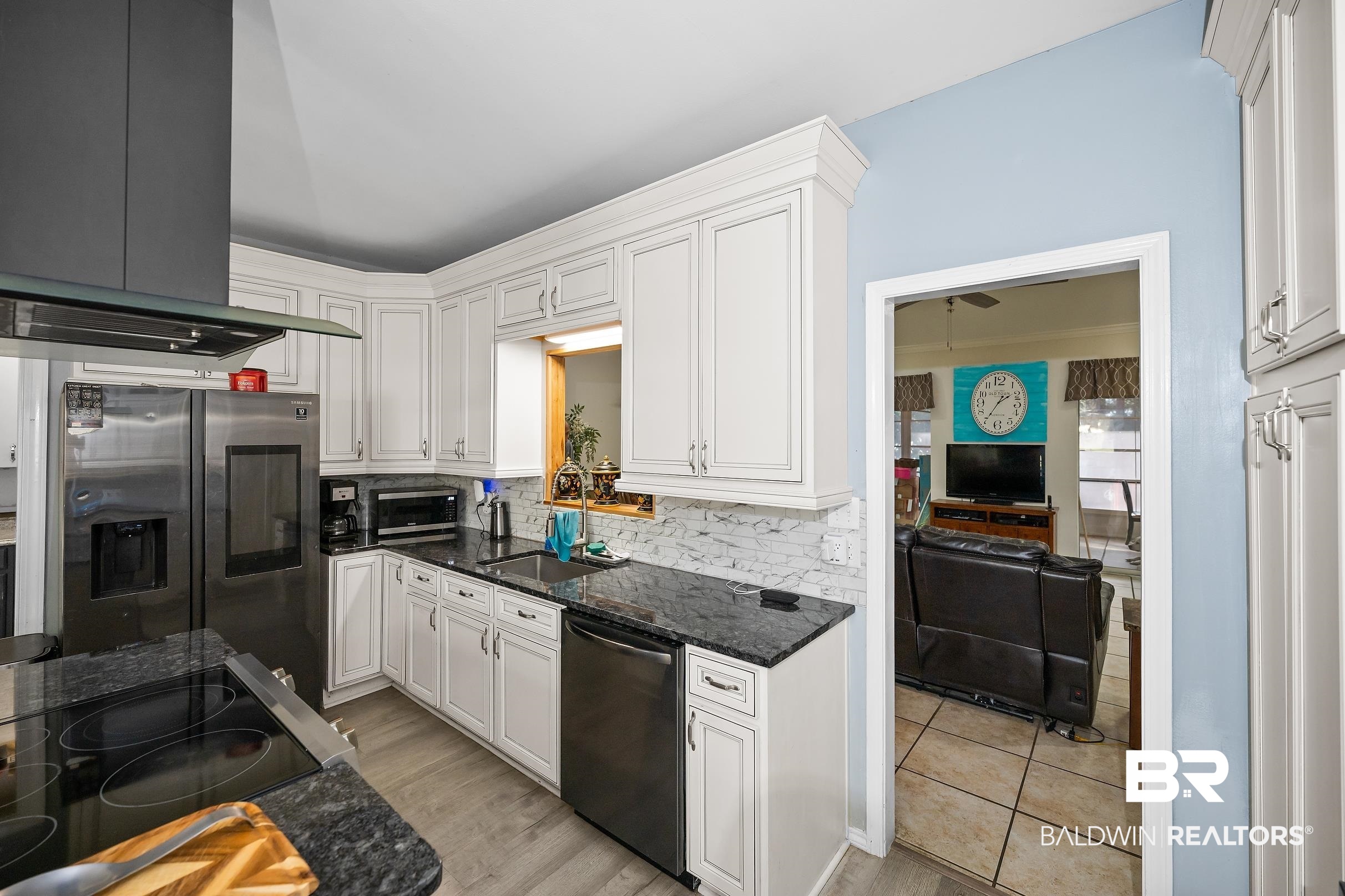 2674 Pine Ridge Drive Lillian, AL 36549 - Photo 6 of 42 Kitchen with black electric cooktop, dark stone countertops, ventilation hood, dishwasher, and stainless steel fridge with ice dispenser