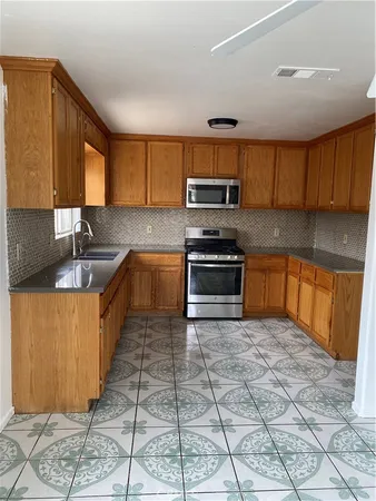 a kitchen with stainless steel appliances granite countertop a stove sink and cabinets