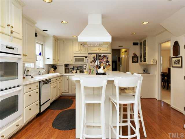 4413 Pitt Street Raleigh, NC 27609 - Photo 15 of 25 a kitchen with stainless steel appliances kitchen island granite countertop a table chairs sink and cabinets