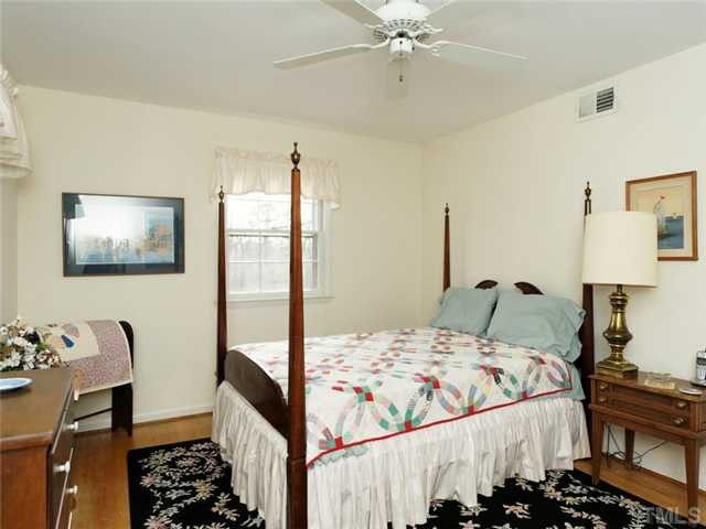 4413 Pitt Street Raleigh, NC 27609 - Photo 23 of 25 a bedroom with a bed and a chandelier