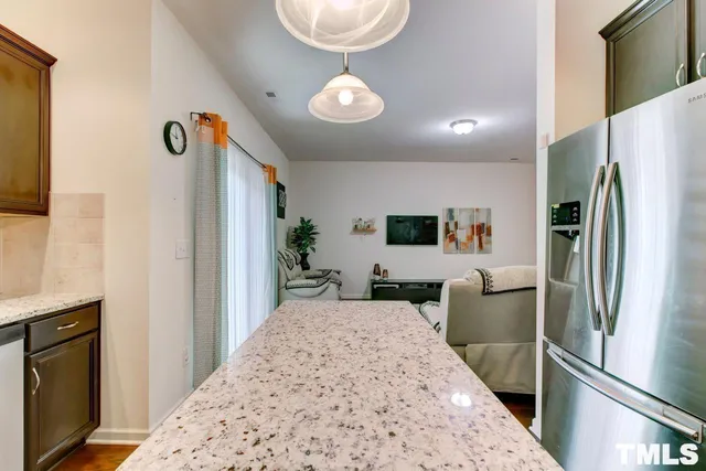 a view of a kitchen with kitchen island stainless steel appliances refrigerator stove and microwave
