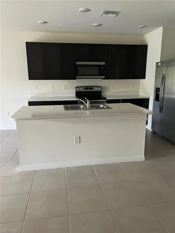 a view of kitchen with stainless steel appliances a stove a microwave and a refrigerator