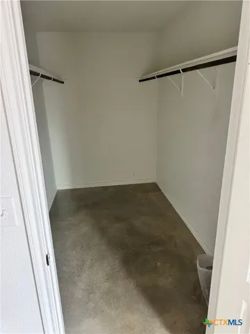 an empty room with windows and ceiling fan