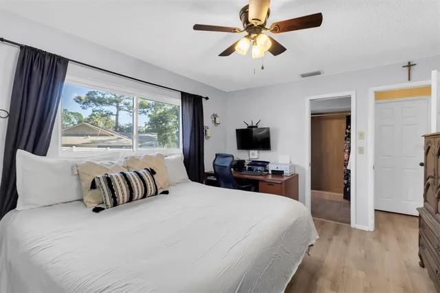 a bedroom with a large bed and a flat tv screen on dresser