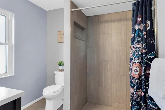 a white toilet sitting next to a shower curtain