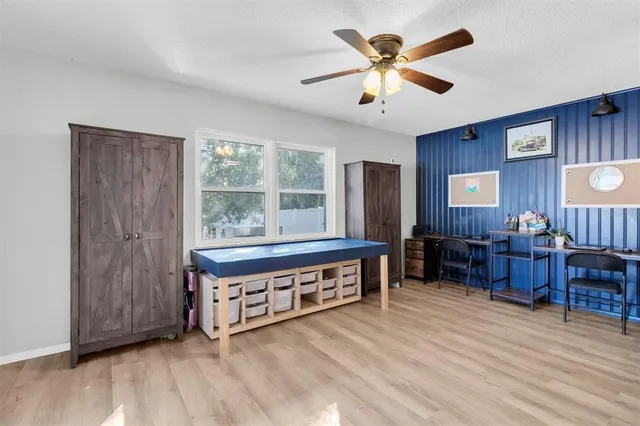 a living room with furniture a desk and chair with a large window