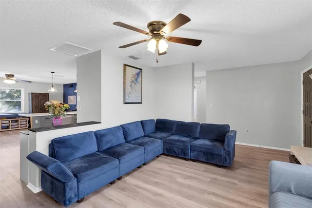a living room with furniture and a ceiling fan