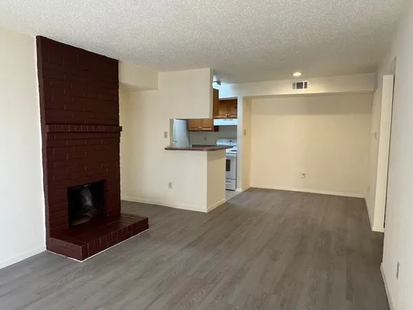 a view of a kitchen with wooden floor and a fireplace