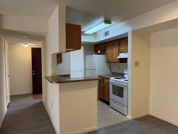 a kitchen with granite countertop a stove and a refrigerator