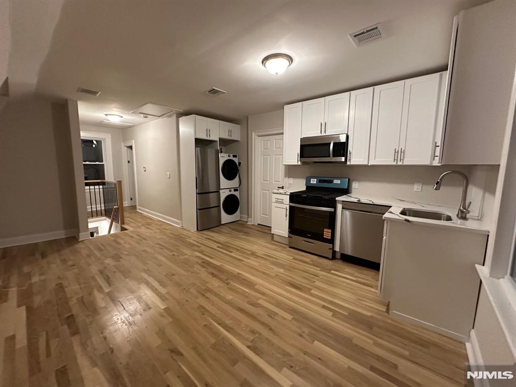 65 Lincoln Place, Unit 2 Garfield, NJ 07026 - Photo 11 of 13 a kitchen with granite countertop a refrigerator and a stove top oven