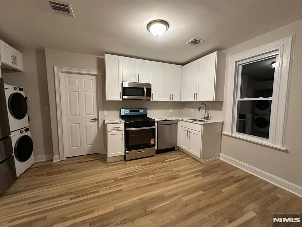 65 Lincoln Place, Unit 2 Garfield, NJ 07026 - Photo 12 of 13 a kitchen with a refrigerator and a stove top oven