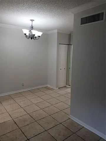 an empty room with chandelier fan