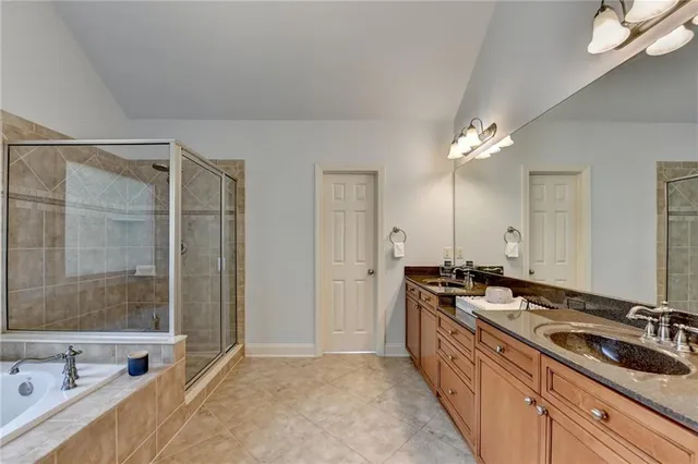 a spacious bathroom with a double vanity sink a mirror and a bathtub