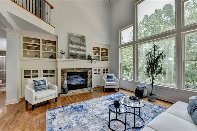 a living room with furniture large window and a fireplace