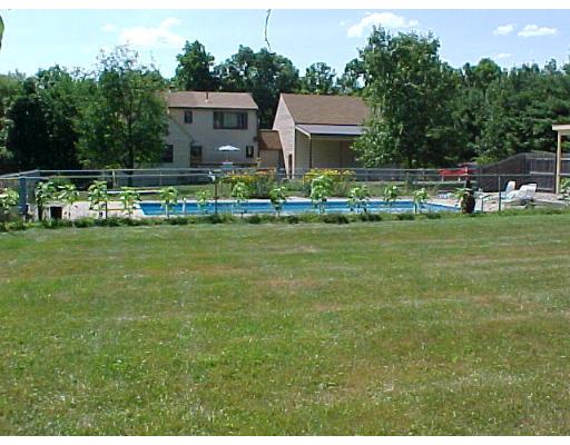 466 Warren Wright Road Belchertown, MA 01007 - Photo 9 of 10 a front view of a house with a garden and trees