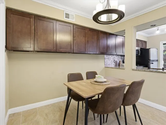 a kitchen with a table chairs and cabinets