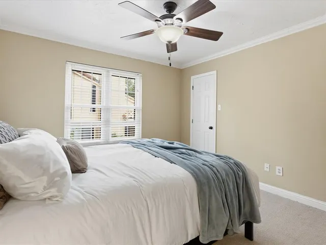 a bedroom with a bed and a large window