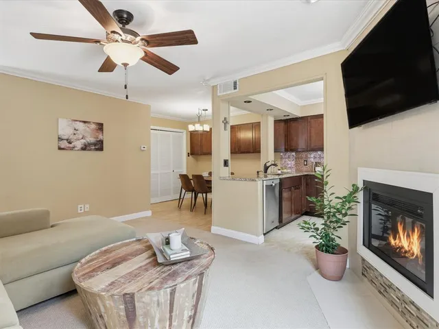 a living room with furniture a flat screen tv and kitchen view