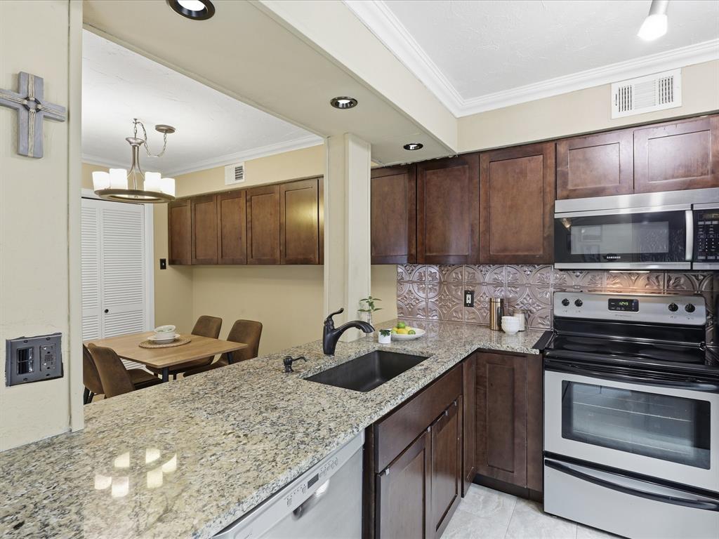 4250 Madera Road Irving, TX 75038 - Photo 9 of 31 a kitchen with stainless steel appliances granite countertop a sink stove and microwave