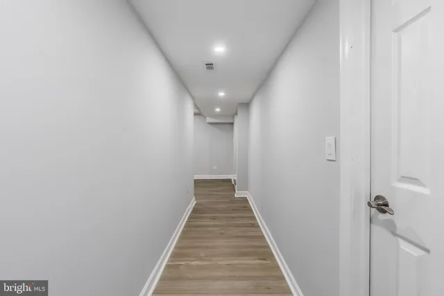 a view of an empty room with wooden floor