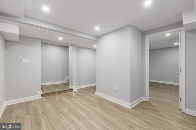 an empty room with a wooden floor and painting on the wall