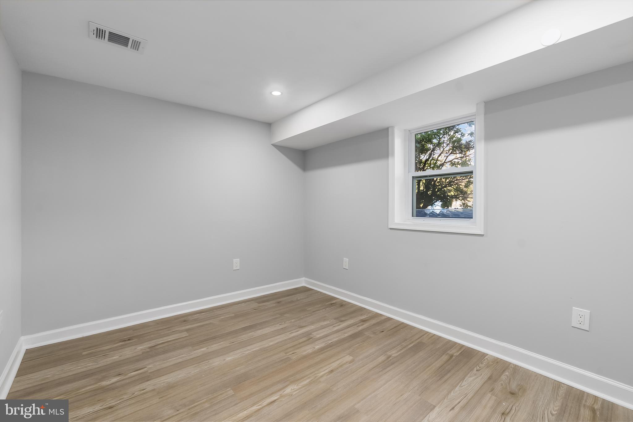 1401 18th Place Southeast Washington, DC 20020 - Photo 27 of 38 an empty room with a wooden floor and painting on the wall