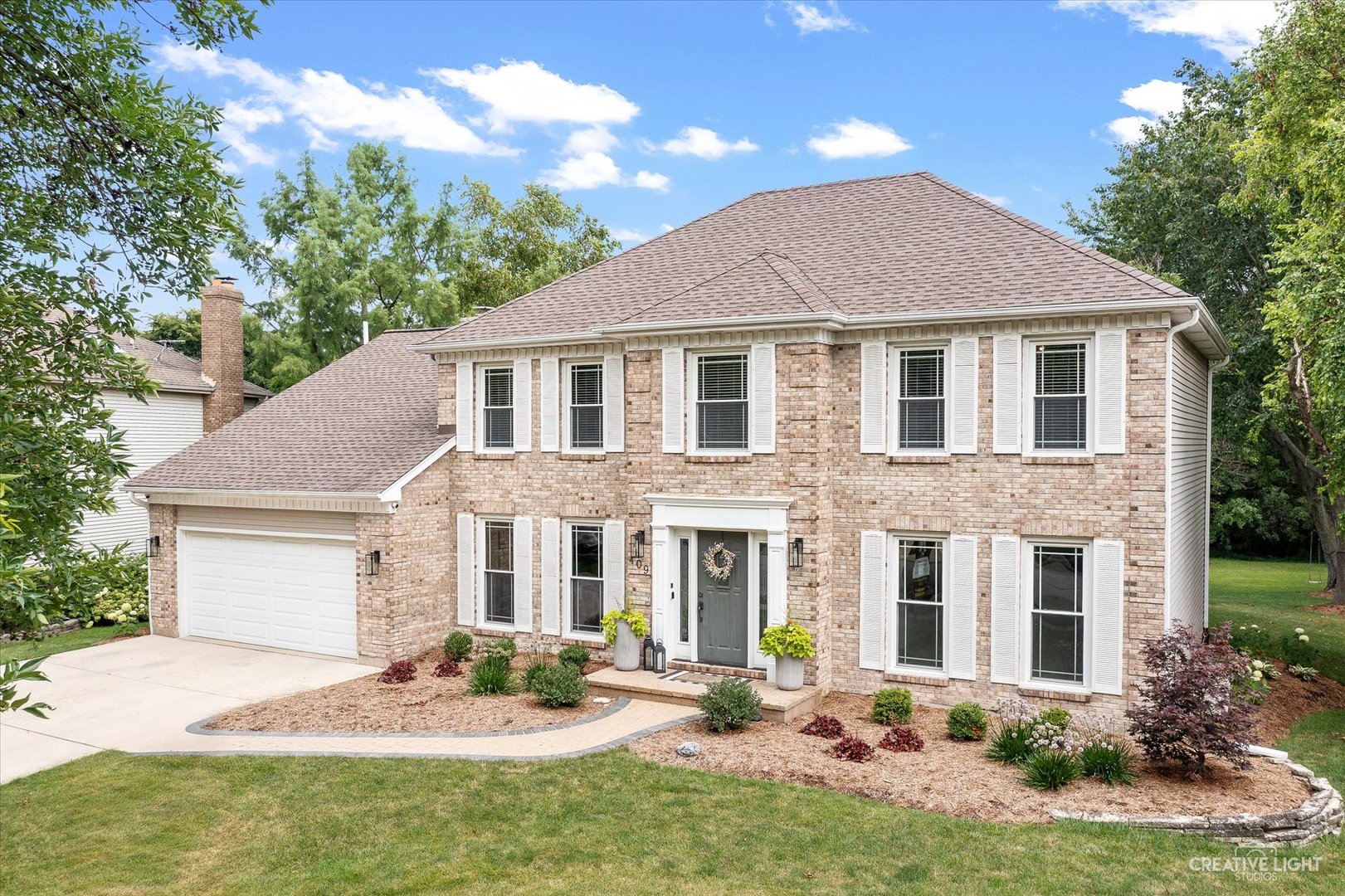 a front view of a house with yard and green space