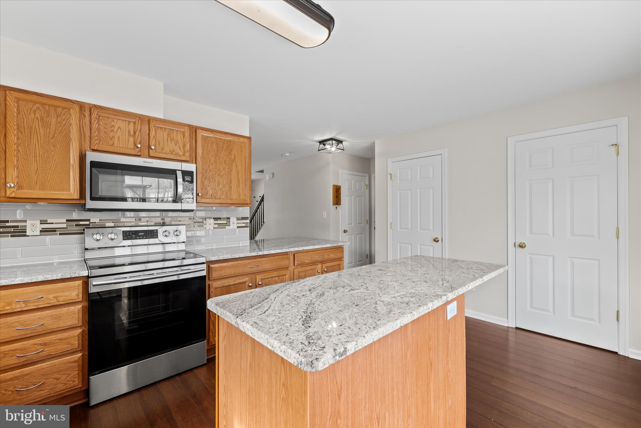 19095 Carey Lane Georgetown, DE 19947 - Photo 11 of 39 a kitchen with stainless steel appliances granite countertop a stove top oven a sink and dishwasher with wooden floor