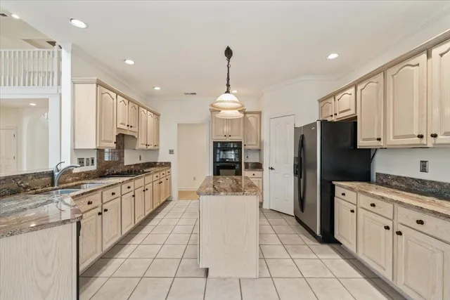 a large kitchen with stainless steel appliances kitchen island granite countertop a sink and cabinets