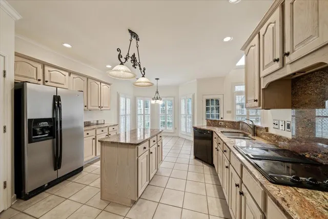 a kitchen with stainless steel appliances granite countertop a refrigerator a sink dishwasher a stove and white cabinets with wooden floor