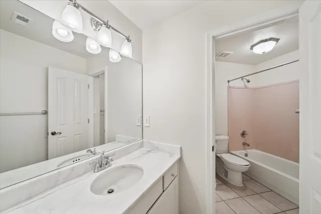 a bathroom with a double vanity sink mirror and toilet