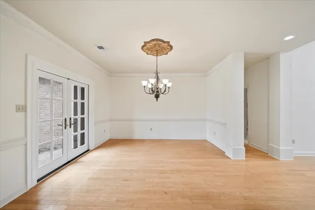 a view of a room with a chandelier fan and wooden floor