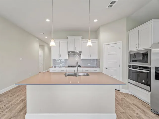 a large kitchen with stainless steel appliances
