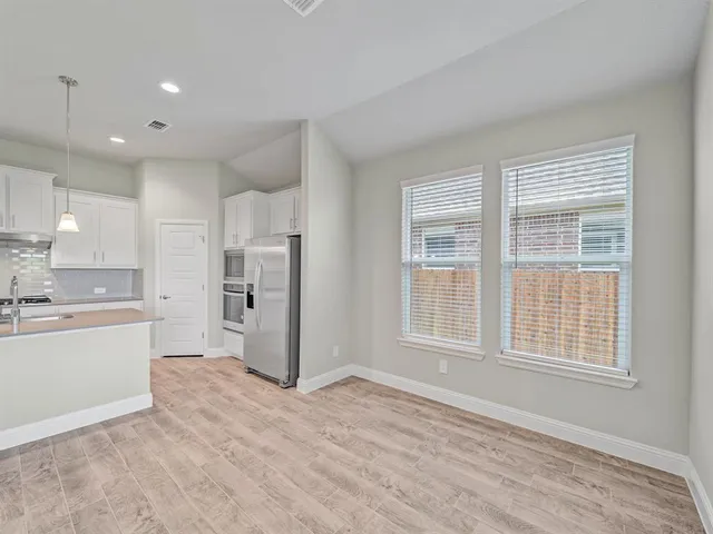 a large kitchen with a refrigerator a sink dishwasher a stove and a refrigerator with wooden floor