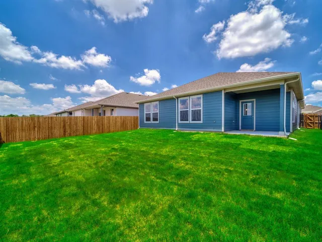 a view of a house with a big yard and large tree