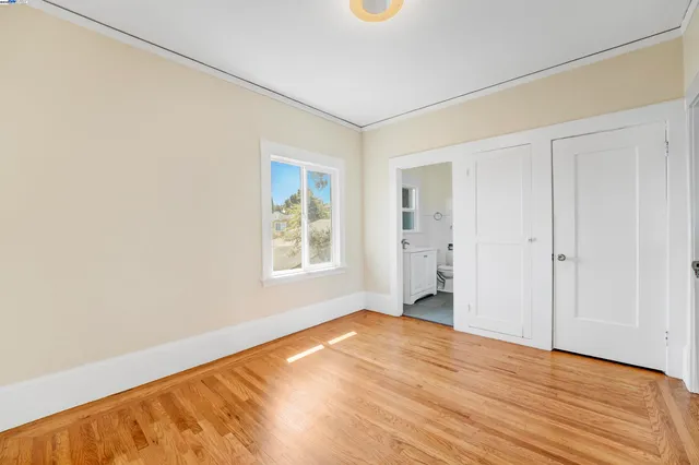 a bedroom with bed and wooden floor