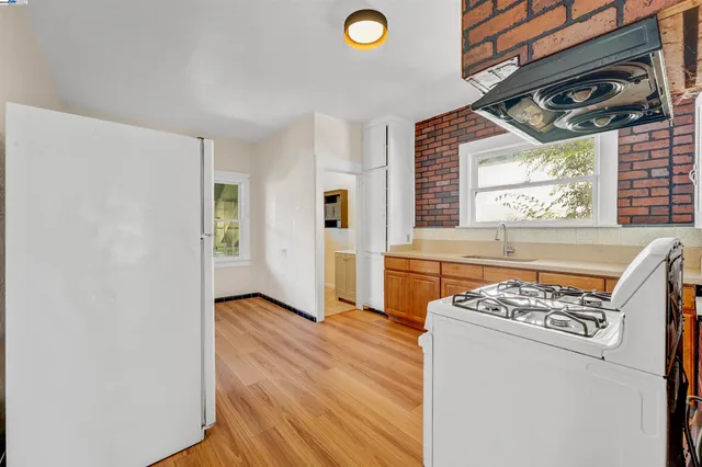 a view of a livingroom with wooden floor and a fireplace