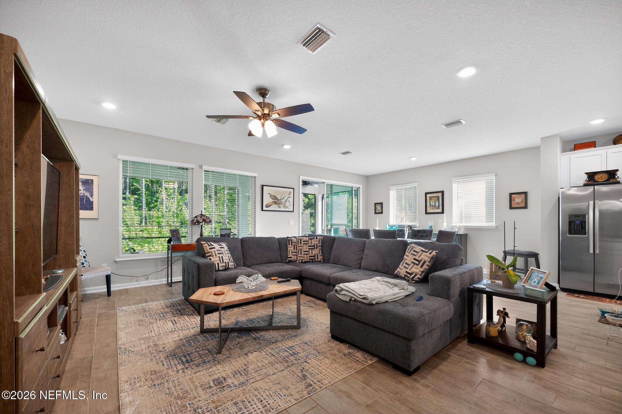 75505 Banyan Way Yulee, FL 32097 - Photo 7 of 30 a living room with furniture a ceiling fan a flat screen tv and a window