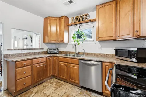 a kitchen with stainless steel appliances granite countertop a sink and a stove