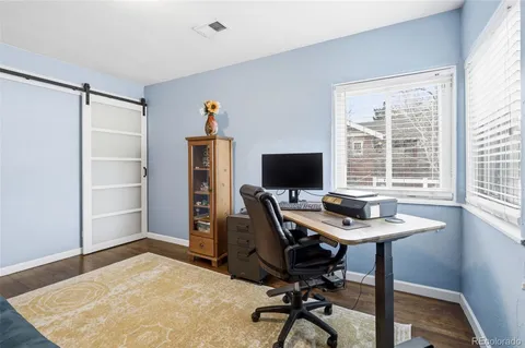 a view of a workspace with furniture and a window